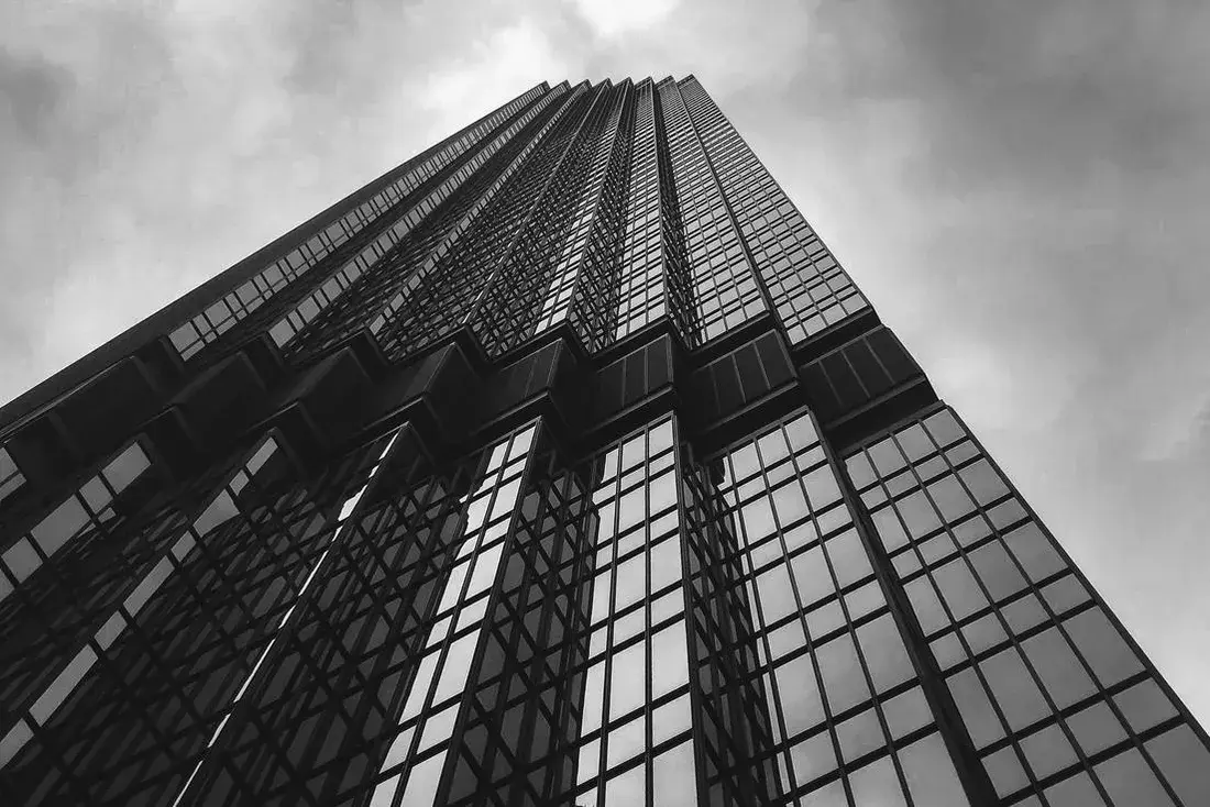 Black and white view looking up a modern high-rise facade