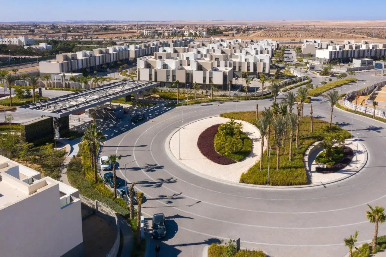Aerial view of the Al Burouj entrance roundabout lined with palm trees
